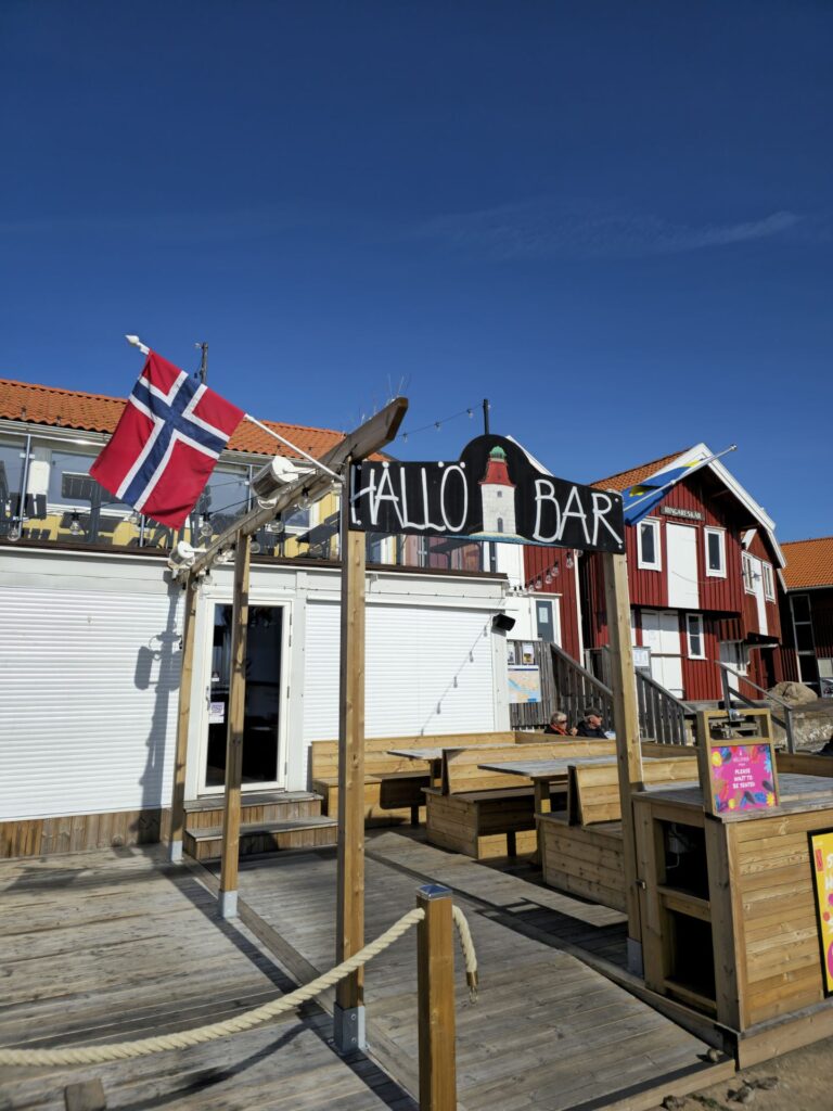 Entrance to Hållö Bar with Norwegian and Swedish flags in front of a white building