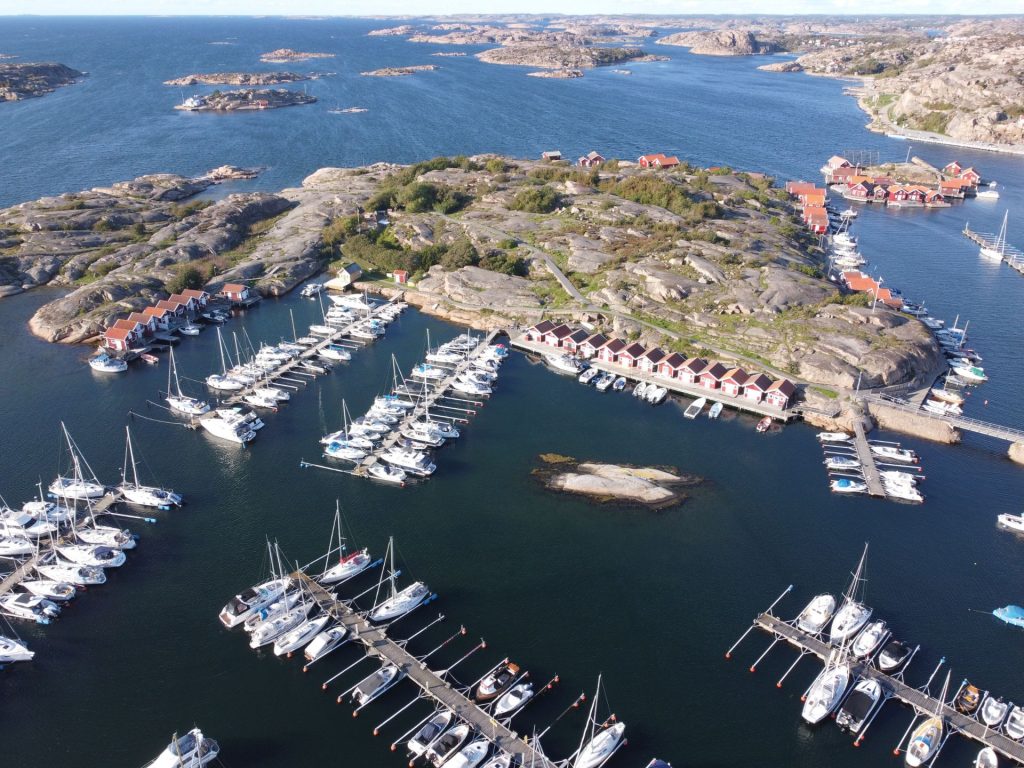 Aerial view of S:t Görans Ö showing the marina, boat slips, and rocky island landscape in Hunnebostrand.